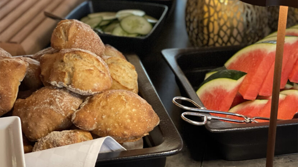 Ett frukostbord med vattenmelon och bröd.